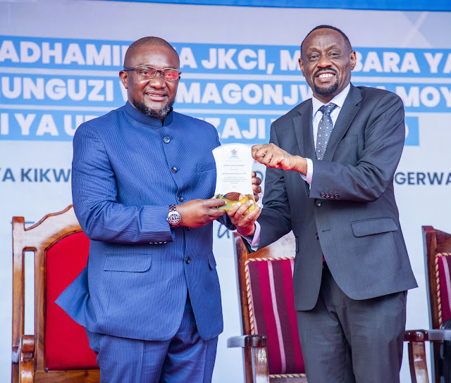 Mkurugenzi Mtendaji wa JKCI Dkt. Peter Kisenge akimpatia tuzo Waziri wa Afya Mhe. Mohamed Mchengerwa