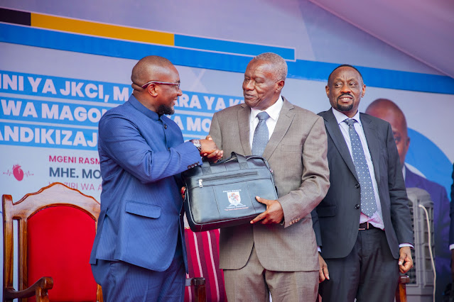 Waziri wa Afya Mhe. Mohamed Mchengerwa akimpatia begi lenye vitendea kazi Mwenyekiti wa bodi ya wadhamini ya Taasisi ya Moyo Jakaya Kikwete (JKCI) Dkt. Hassan Mshinda